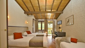Une chambre d’hôtel avec deux lits, un bureau et une vue sur l’extérieur.
