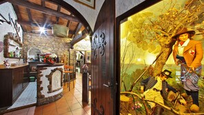 Un intérieur rustique avec des murs en pierre, des poutres en bois et un coin bar.