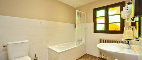 A bathroom with a toilet, bathtub, and sink.