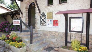 A stone building with a sign reading "ACCUEIL" and a plaque.