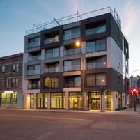 Un immeuble à plusieurs étages doté d’une architecture moderne, avec des balcons et de grandes fenêtres.