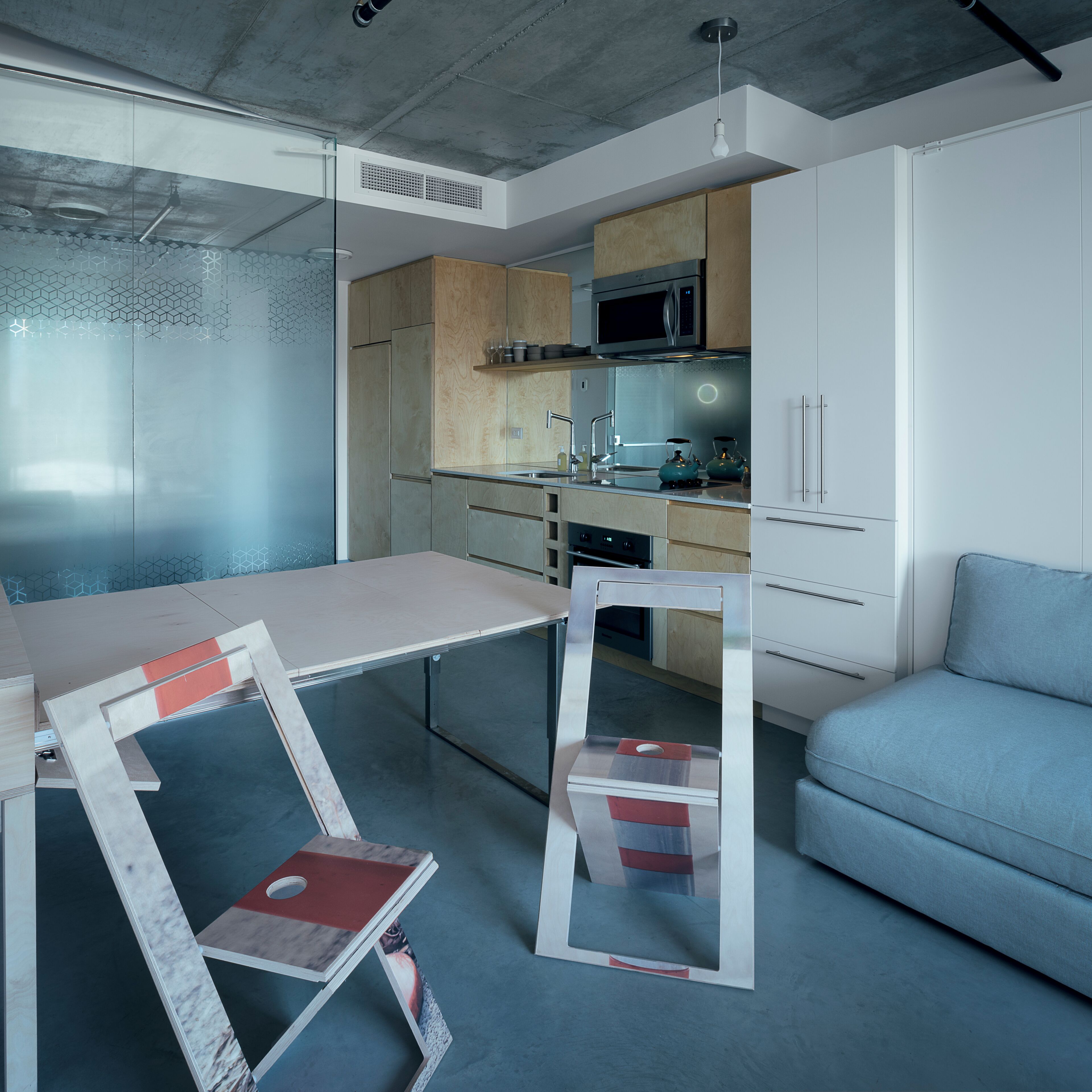 A modern kitchen with a microwave, kettle, and cabinets.