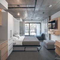 Une chambre moderne avec un lit, des tables de chevet, une télévision et une grande fenêtre.