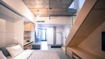 A modern hotel room with a large bed, a desk, and a walk-in closet.