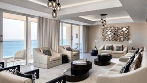 Amplio salón con un gran ventanal con vista al mar, una lámpara moderna y un adorno de pared.
