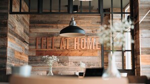 Un interior rústico con una pared de madera y la frase "FEEL AT HOME" destacada.