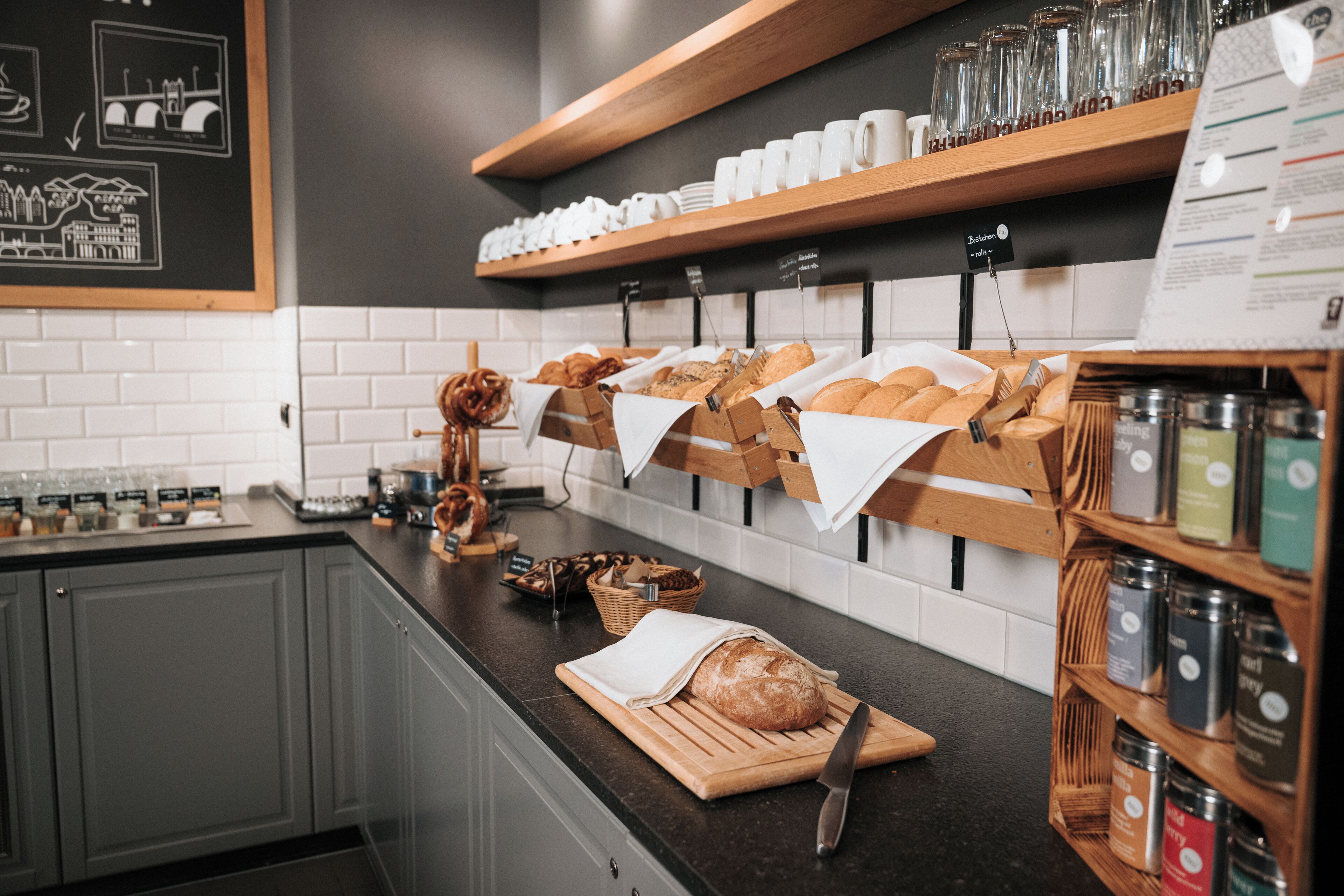 A bakery counter with bread, pastries, and jars of spreads.