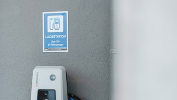 Une borne de recharge avec un panneau indiquant qu’elle est réservée aux véhicules électriques.