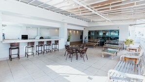 A spacious indoor area with a bar, seating, and a view of the city. - Victory Suites (Juiz de Fora)