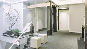 Un interior moderno con una escalera, una planta en maceta y una puerta.