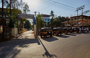 Una señal de calle para Galaxy's Vaibhav Family Rest & Bar, con tuk-tuks estacionados al lado.