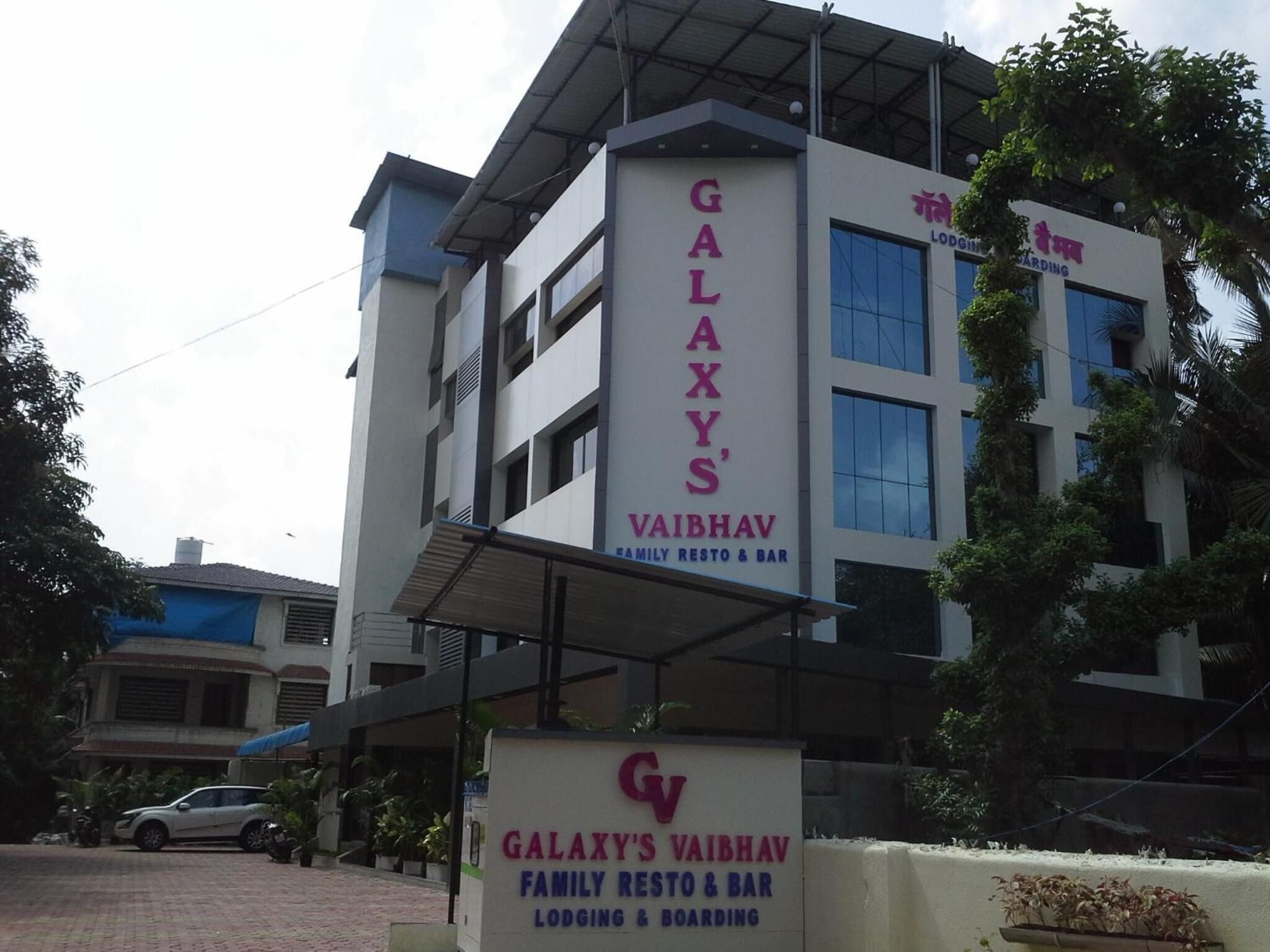 A building with a sign for Galaxy's Vaibhav, indicating it is a family resto & bar, lodging, and boarding facility.