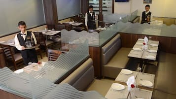 A restaurant with booths and tables, some with glass partitions.