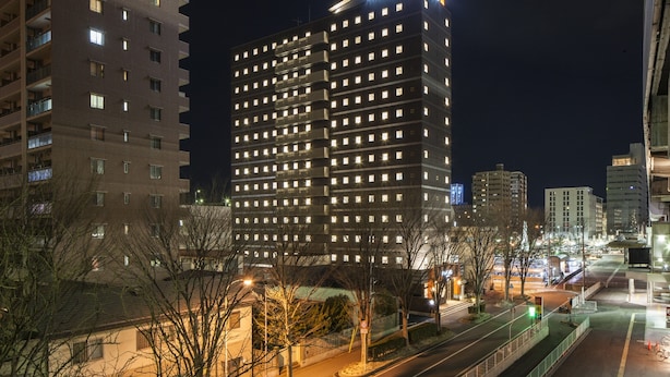 A high-rise hotel with multiple floors, illuminated windows, and a prominent sign at the top. - APA Hotel Fukushima Ekimae (Fukushima)