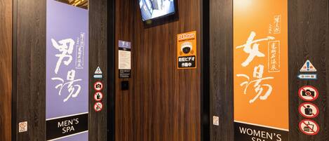 A men's and a women's spa with wooden paneling and a security system sign.