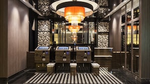 A lobby with a modern chandelier, check-in kiosks, and patterned wallpaper. - APA Hotel Fukushima Ekimae (Fukushima)