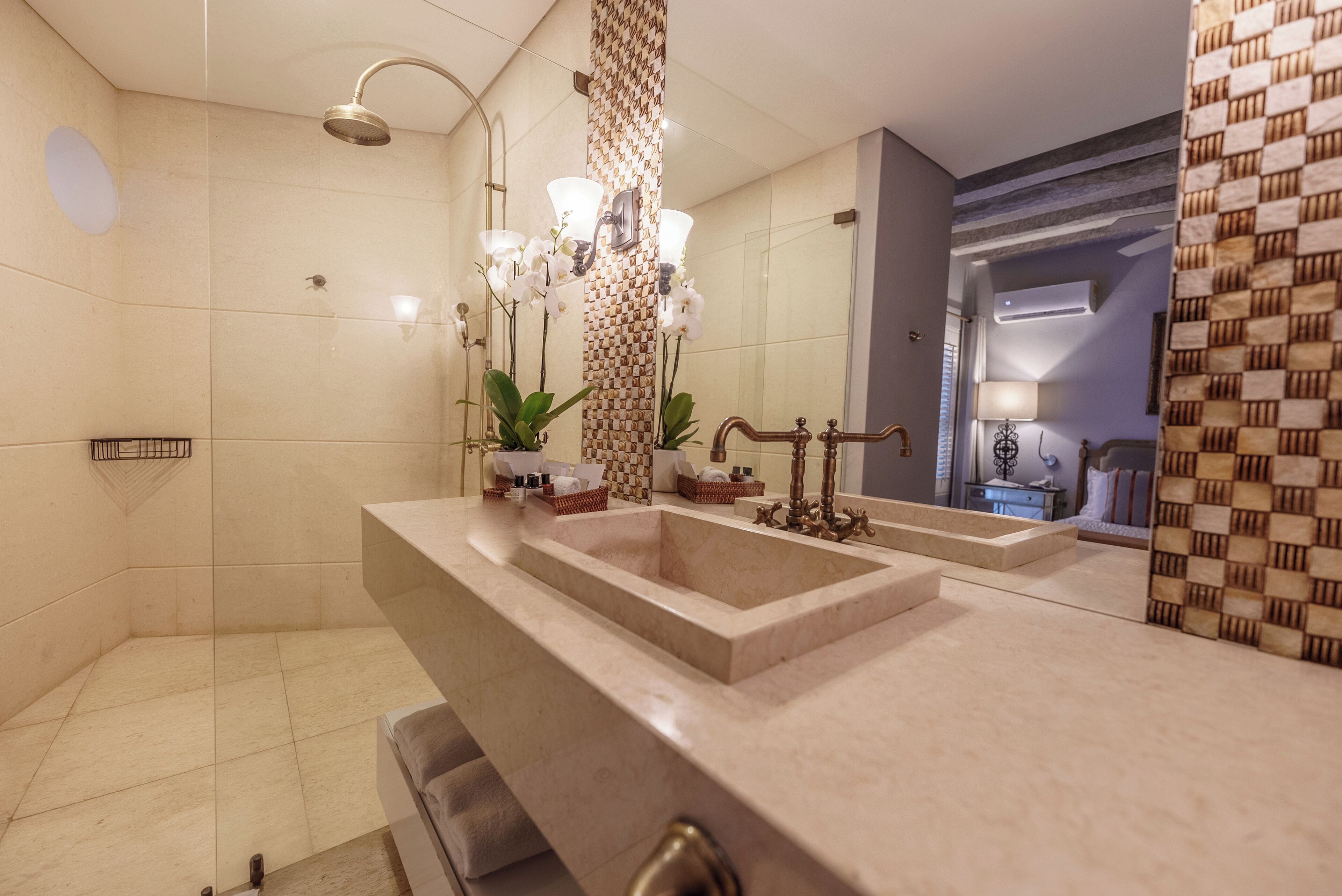 Een moderne badkamer met een groot wastafel, twee spiegels, een douchekop en decoratieve planten.