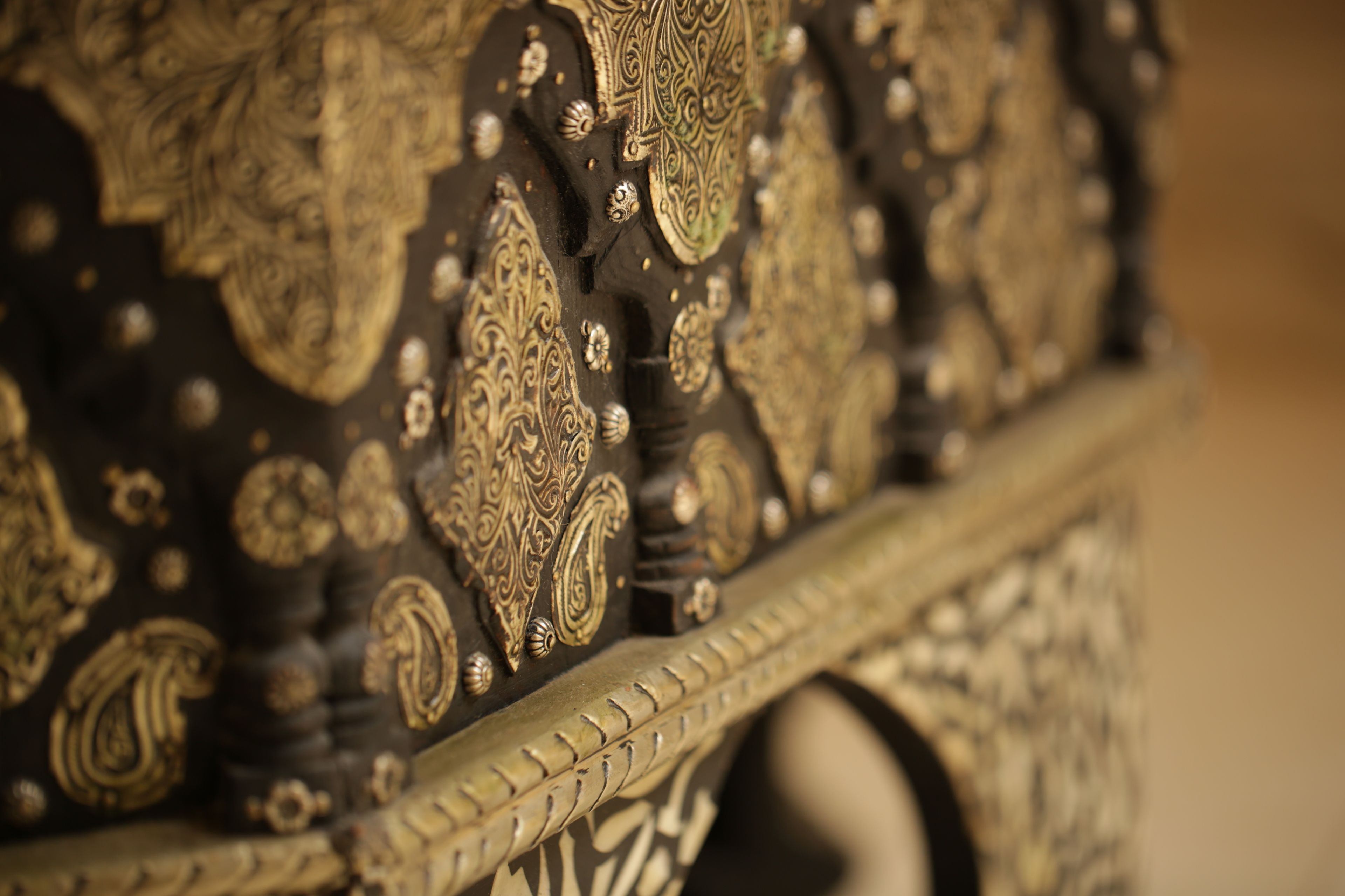 A close-up of ornate, gold-accented furniture with intricate designs and patterns.