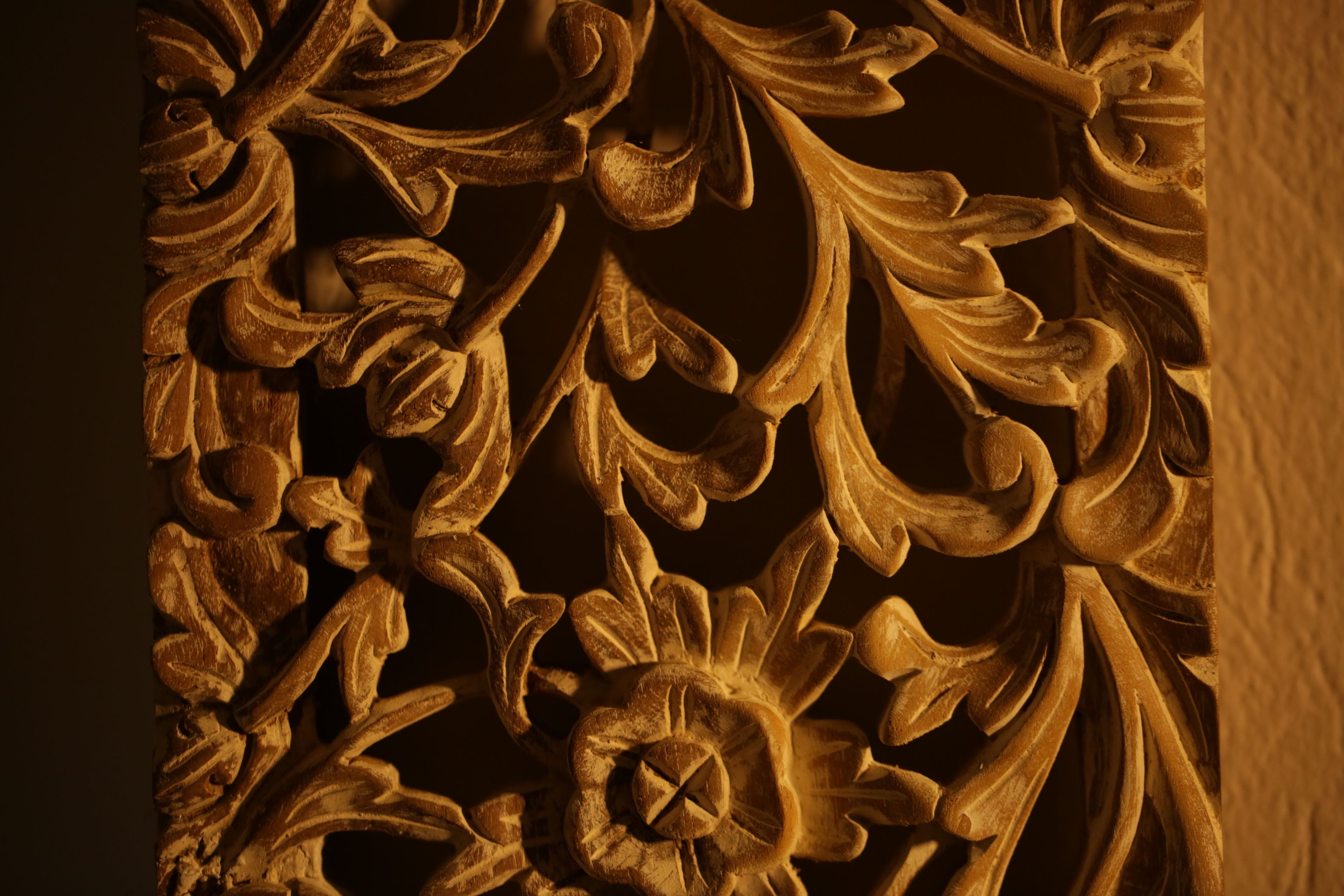 A detailed carved wooden panel with floral and geometric patterns.