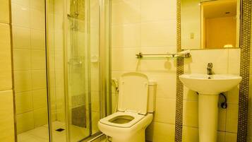 Un baño con ducha de vidrio, inodoro y lavabo.