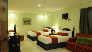 A hotel room with two single beds, a sofa, a desk, and a television. - Dreamwave Hotel Santiago City (Santiago City)