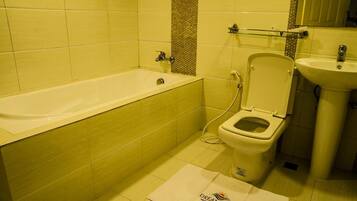A bathroom with a bathtub, toilet, and sink.
