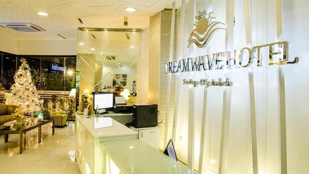 A reception area with a modern design, featuring a reception desk, a Christmas tree, and a sign that reads "DreamWave Hotel." - Dreamwave Hotel Santiago City (Santiago City)
