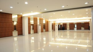 A spacious, modern lobby with a polished floor, recessed lighting, and a symmetrical design featuring wooden panels and white columns. - Dreamwave Hotel Santiago City (Santiago City)