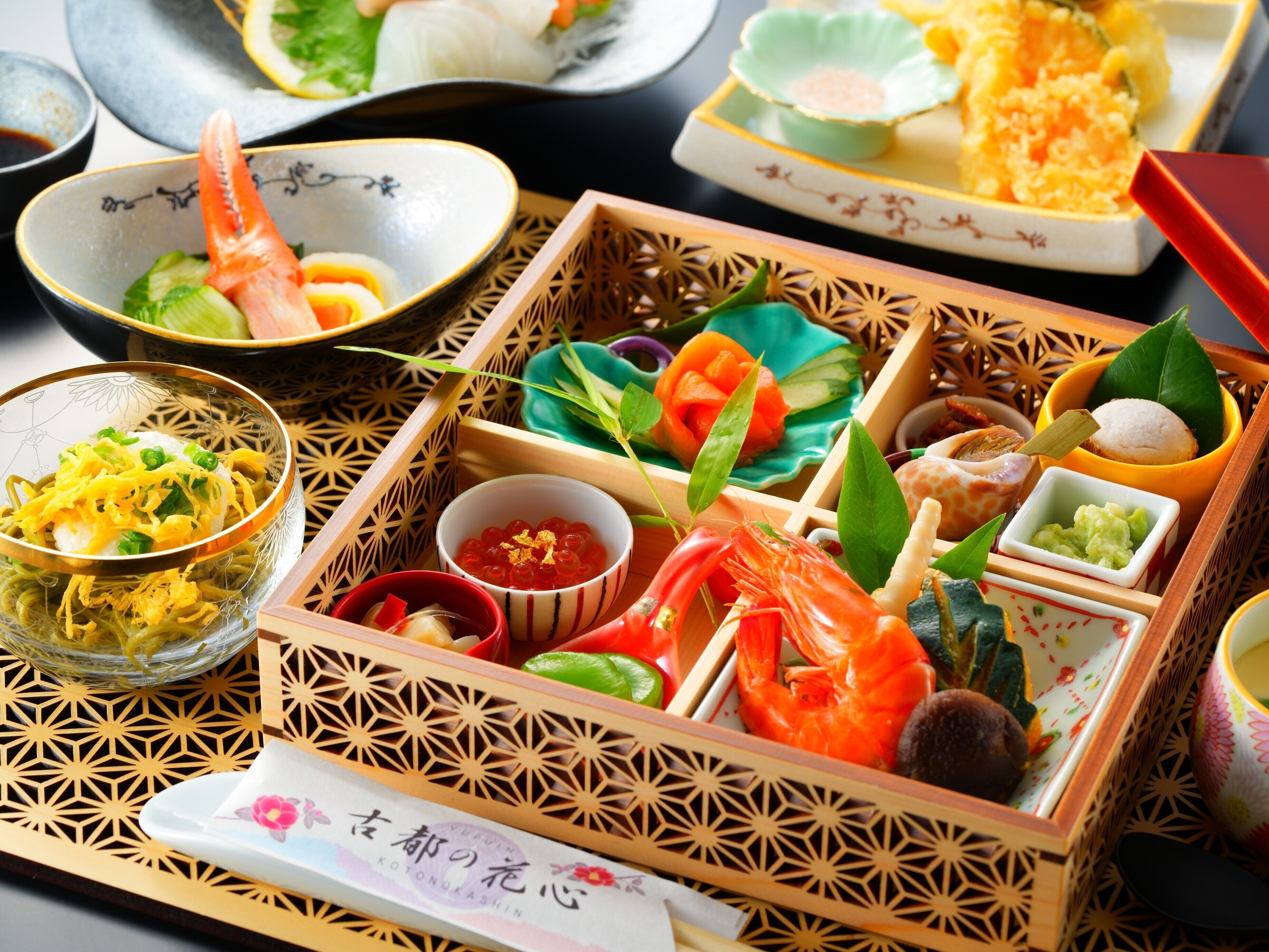 A traditional Japanese bento box with various dishes including seafood, vegetables, and rice.