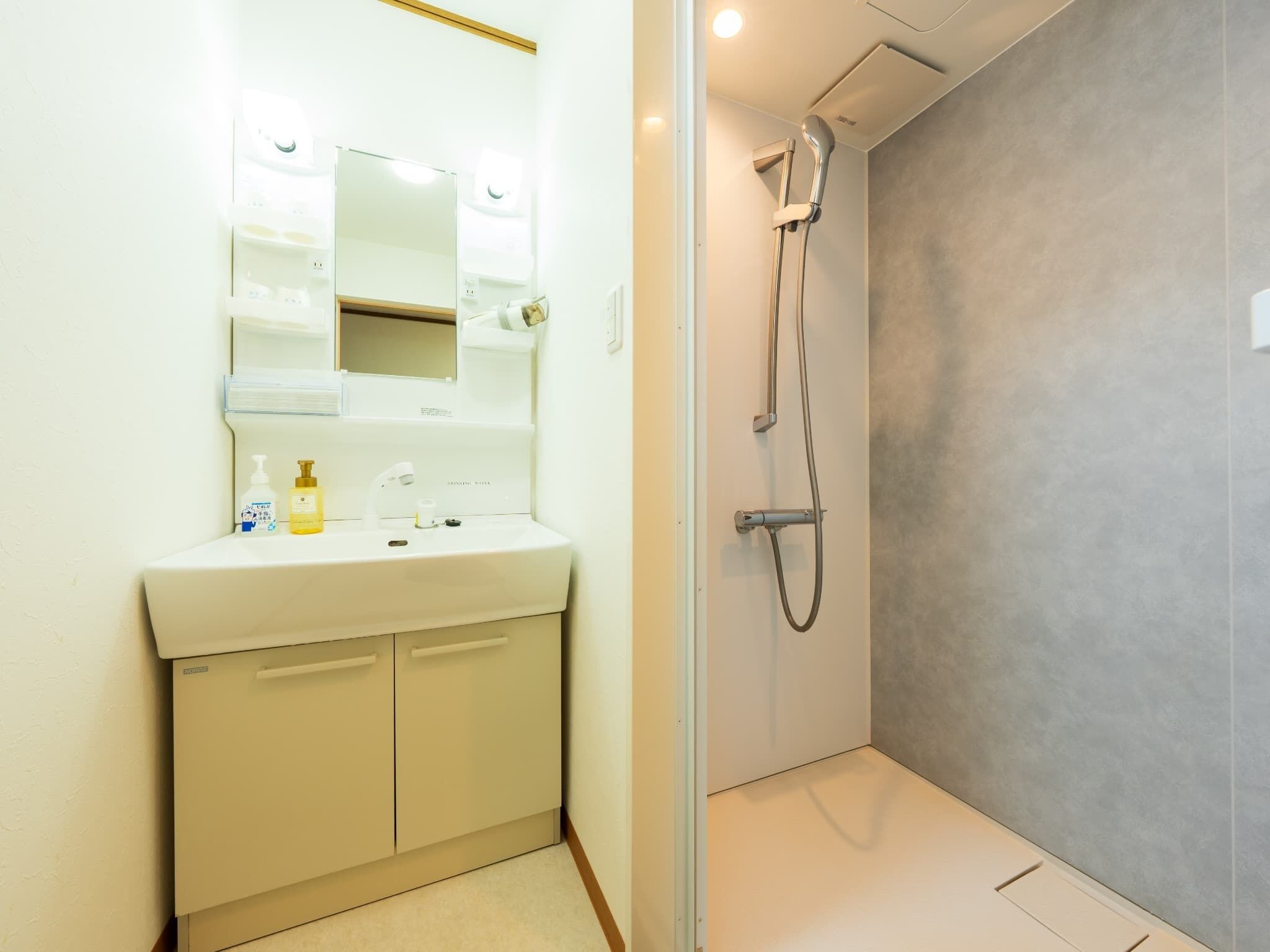 Ein Badezimmer mit Waschbecken, Spiegel und Dusche.