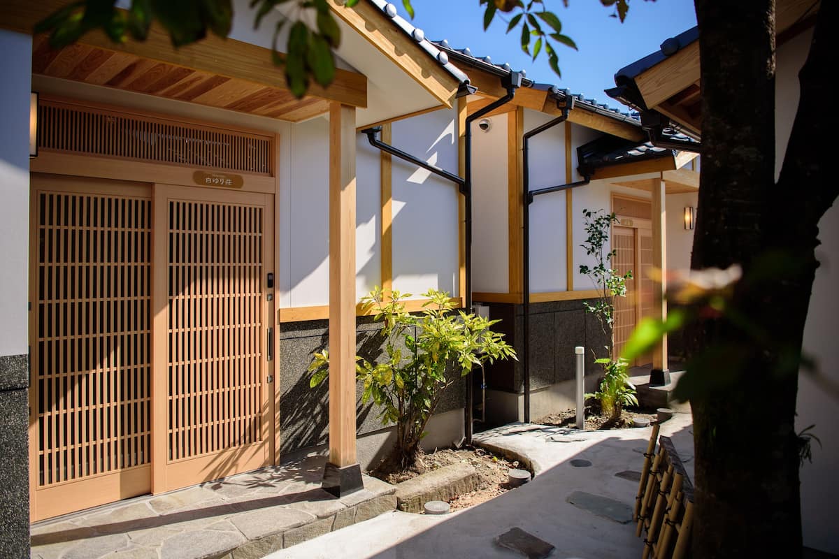 Ein traditionelles japanisches Gebäude mit Holztüren und einem Steinweg.