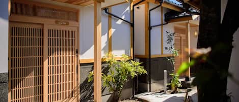 Un edificio japonés tradicional con puertas de madera y un camino de piedra.