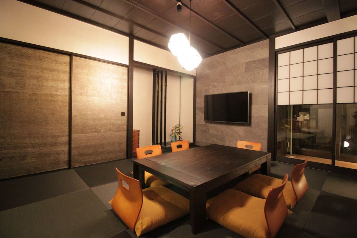 A conference room with a large table, chairs, a TV, and sliding doors.