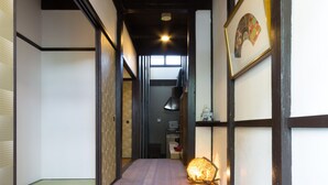 Un couloir étroit, doté d’un plancher en bois et d’un tapis bleu à l’extrémité.