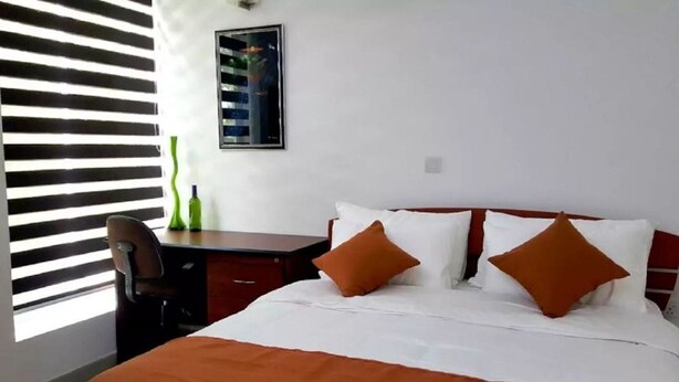 Een hotelkamer met een bed, een bureau en een stoel.