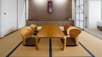 A traditional Japanese-style room with tatami flooring, a low wooden table, and woven chairs.