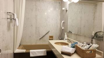 A modern bathroom with a bathtub, a shower, a sink, and a mirror.