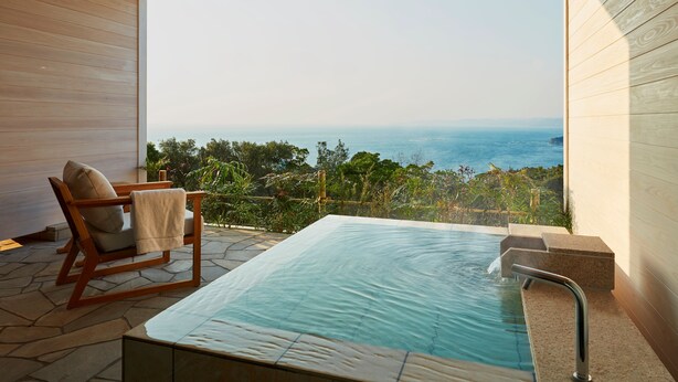 A spa area with a hot tub and a chair, overlooking a scenic view.