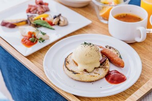 Un desayuno con platos de comida, una taza de café y una mesa de madera.