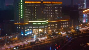 Un hotel de varios pisos con letreros iluminados y una entrada destacada.