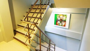 A staircase with metal railings and a framed artwork on the wall. - Villa Cha-Cha Khaosan-Rambuttri (Bangkok)