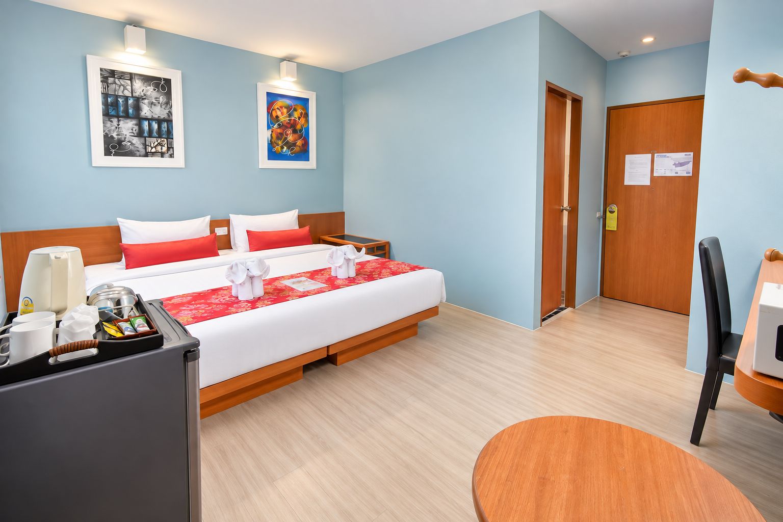 Una habitación de hotel con cama, mesitas de noche, escritorio y una silla.