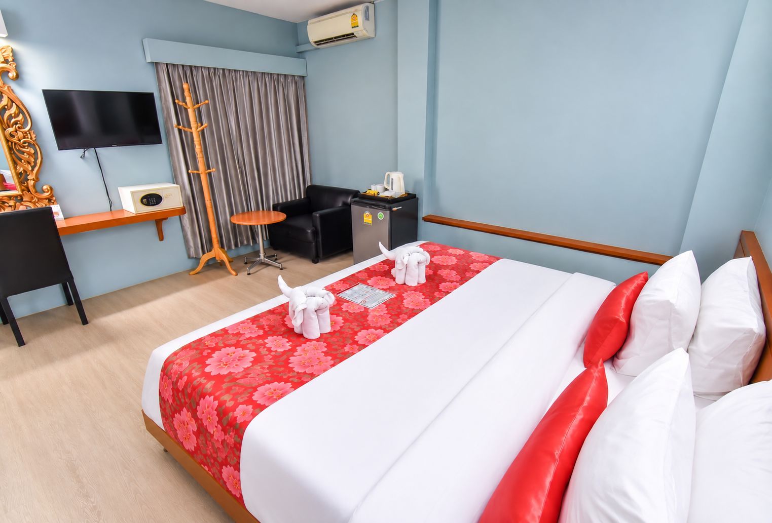 Une chambre d’hôtel équipée d’un lit, d’un bureau, d’une chaise, d’une télévision et d’un appareil de climatisation.