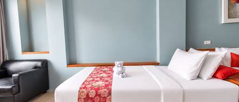 Una habitación de hotel con una cama, una silla, una lámpara de pared y un cuadro.