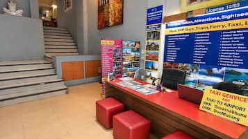 A reception area with a desk, red cushioned seating, and informational posters.