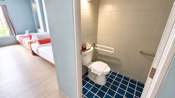 Una habitación de hotel con cama, baño con inodoro y ducha, y vistas al exterior.