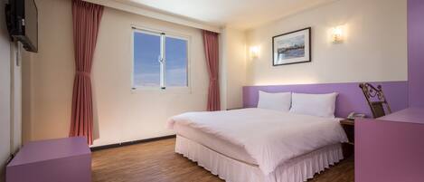 A bedroom with a large bed, a window, a flat-screen TV, and a bedside table.