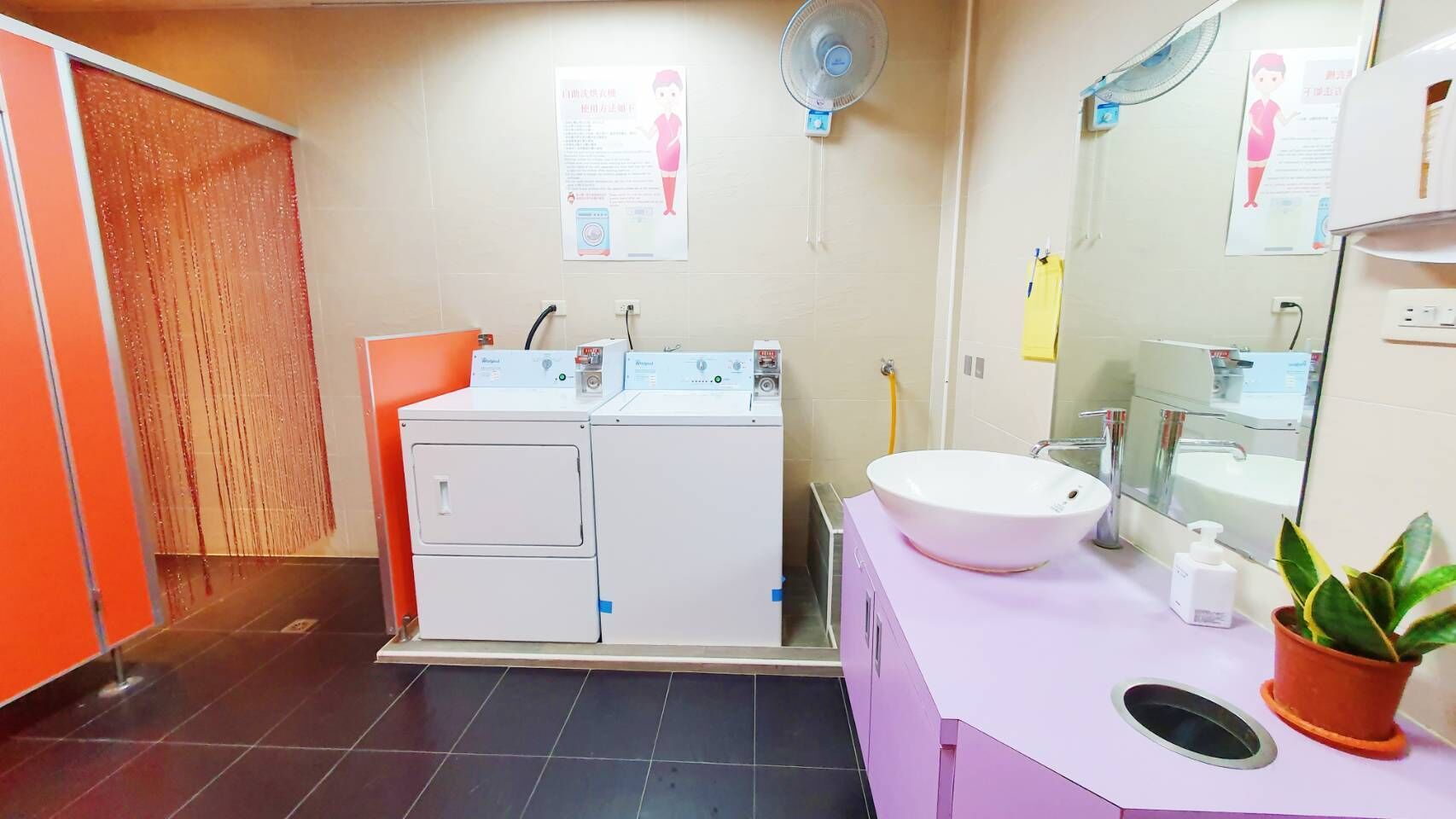 A bathroom with a white sink, a mirror, a fan, and a shower area.