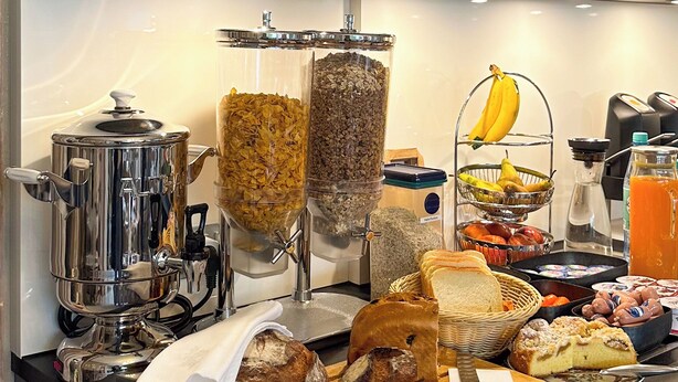 En morgenmadsbuffet med et udvalg af mad og en kaffemaskine.