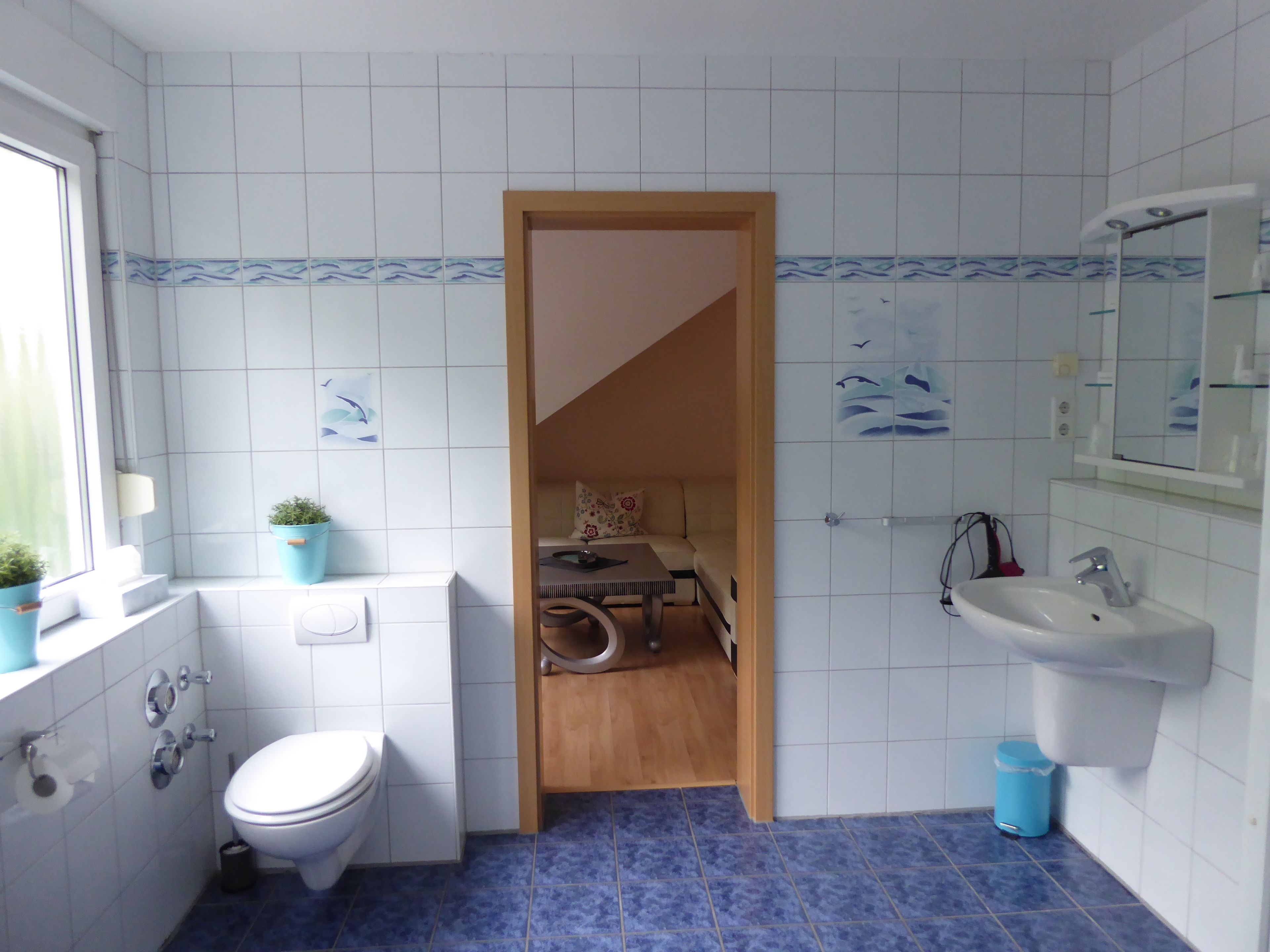 A bathroom with a toilet, sink, and shower area.